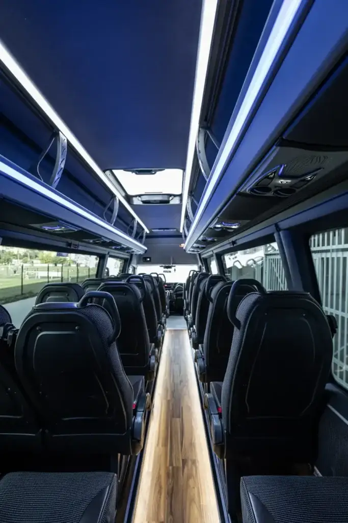 MAIN_Przestrzeń Pasażerów Iveco Bus Widok Od Tyłu Pojazdu Z Podświeleniem Led Podłogi Drewnianej Oraz Pasami Led Fioletowym I Białym U Góry Przejśćia